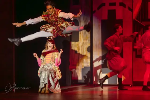 A performer leaping mid-air during a live musical number