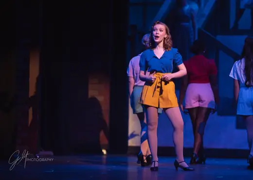 An ensemble musical number in full color on stage