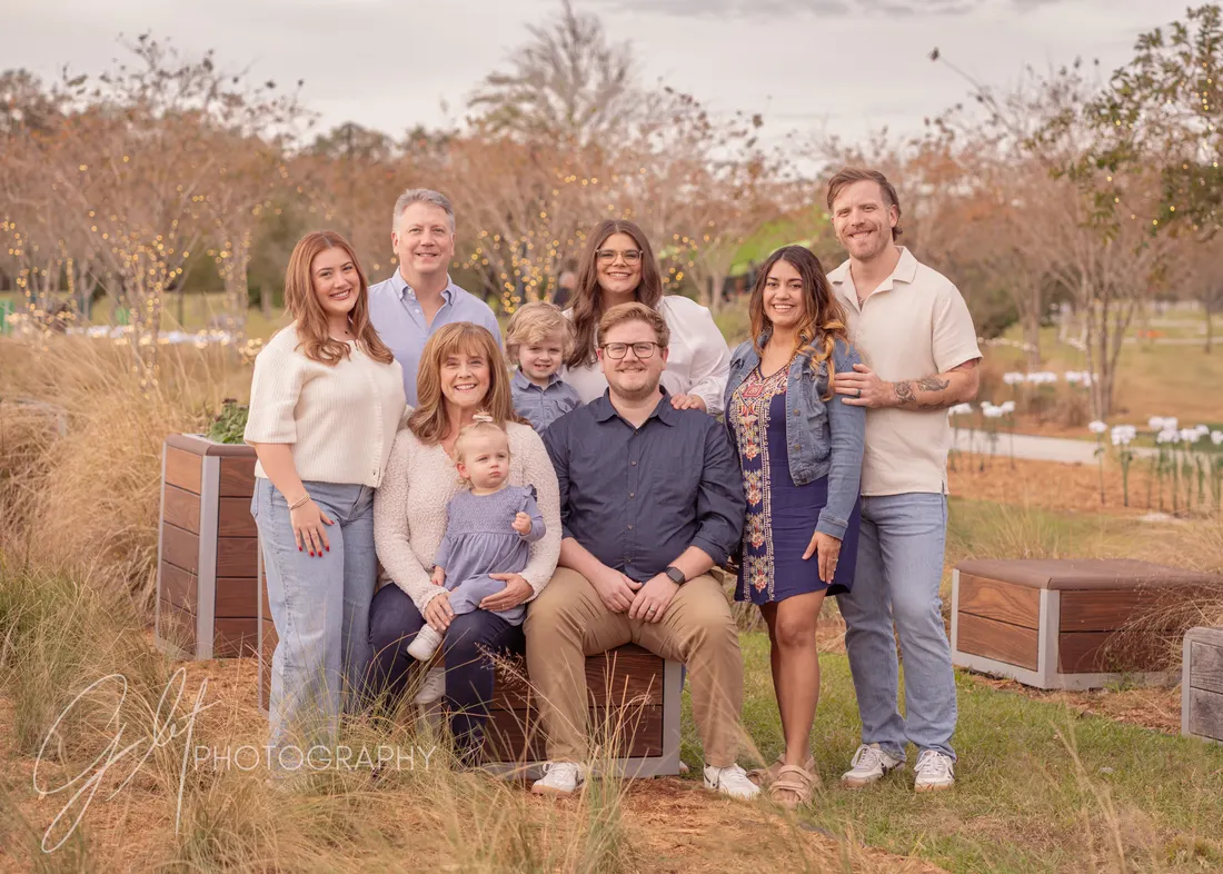 An extended family in coordinated blues, creams, and denim — one palette, no matching, everyone distinct