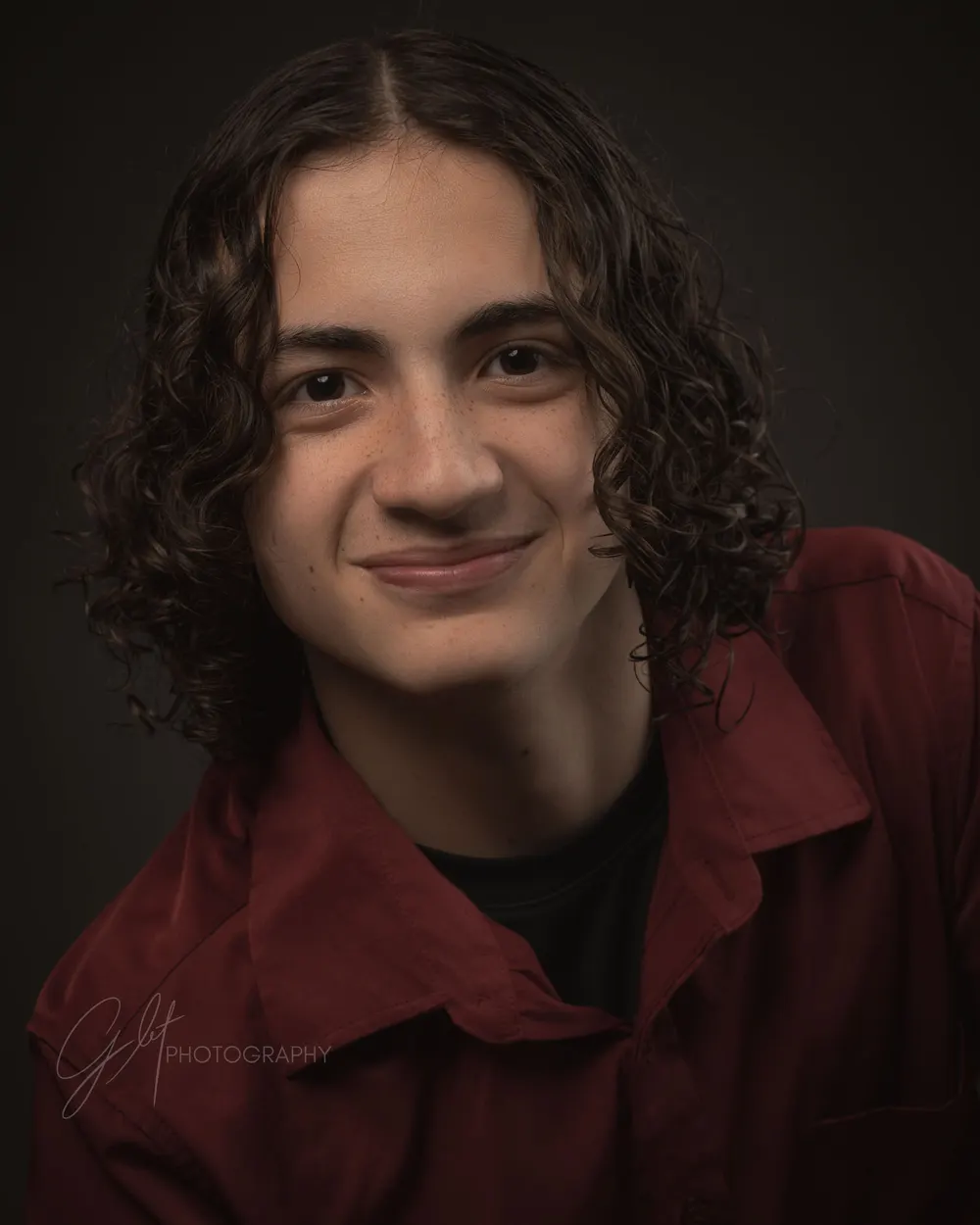 A young man in an open shirt over a dark tee — one layer adding depth and an easy second look