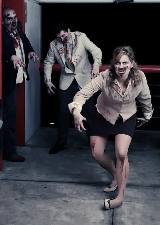 Three actors in zombie makeup lurching toward the camera