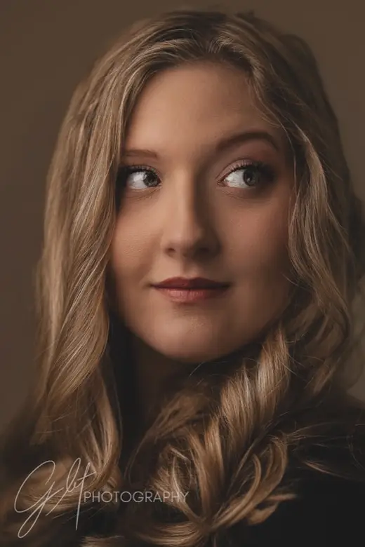 Portrait of a blonde woman glancing over her shoulder in warm light