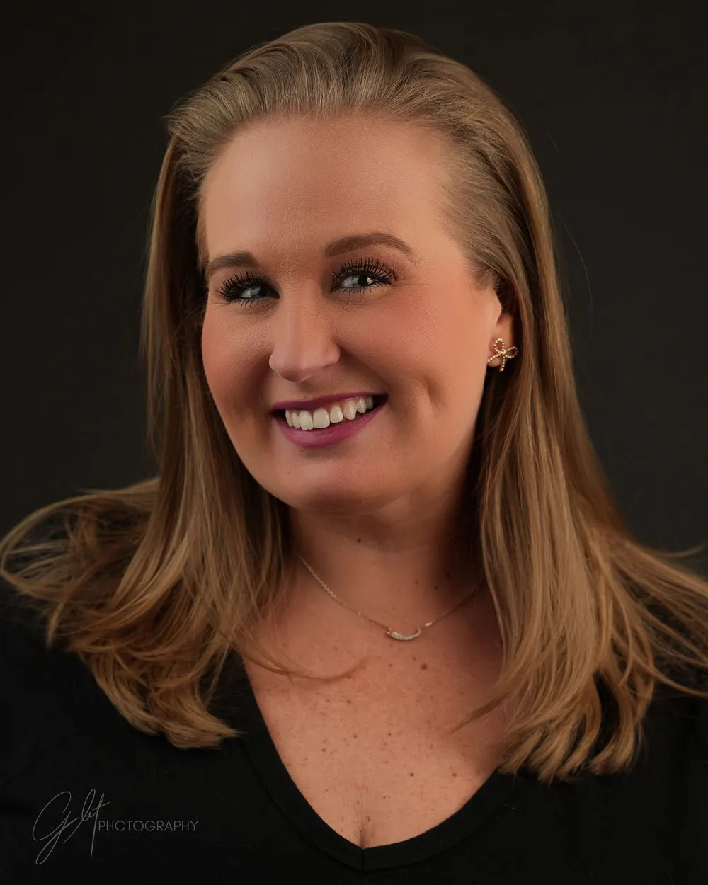 A relaxed, genuinely smiling client mid-session — directed, never stiff