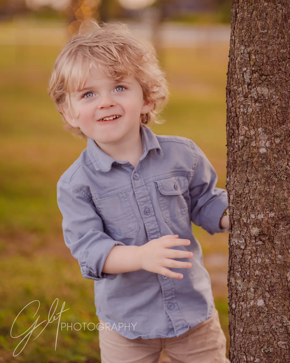 A toddler exploring by a tree mid-session — the unscripted frame that becomes the favorite